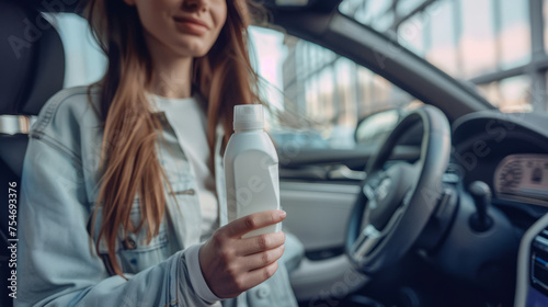 A woman subtly showcases a white bottle while seated in a car, possibly promoting a product