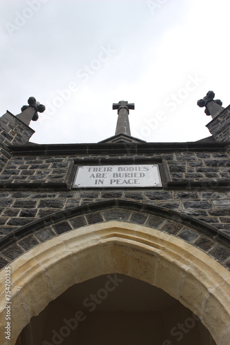 The front of an old stone church with a grey sky background, Christchurch, New Zealand.  photo