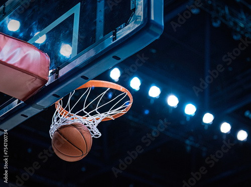 Basketball scoring a basket as it goes through the hoop and making a swish in the net  © Brocreative