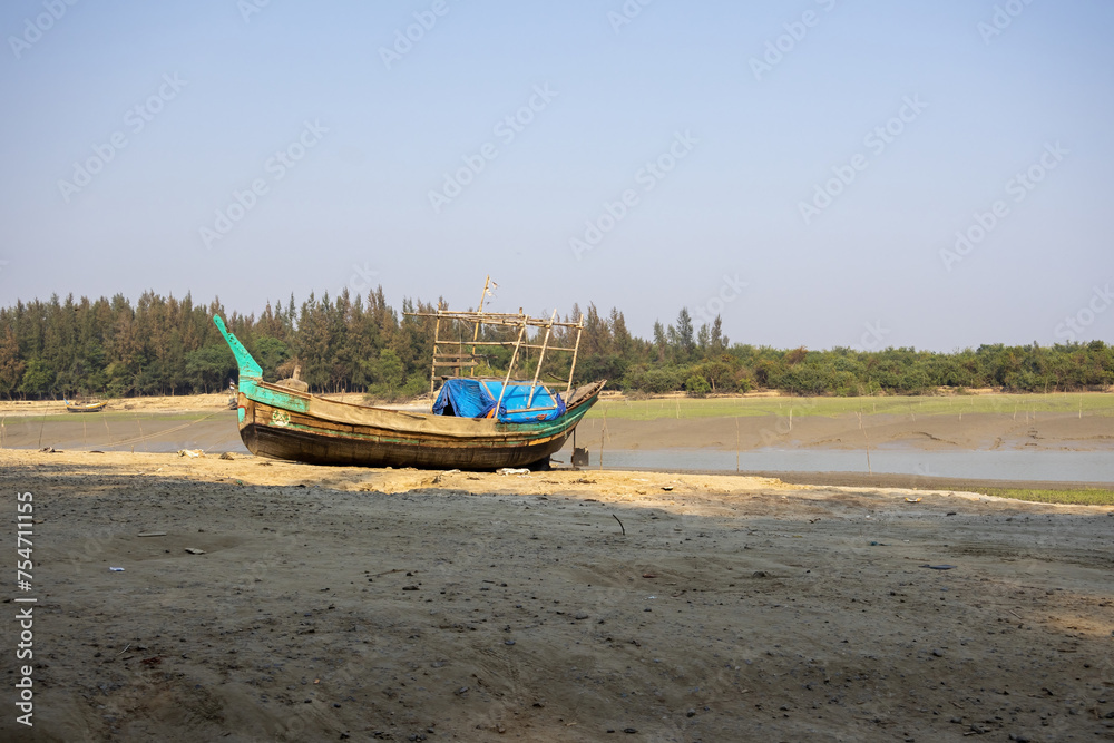 Local fishing boat on the beach. It is placed on the seaside at low tide. This place is known as Noakhali Musapur Closer or Musapur Sea Beach in Bangladesh. 