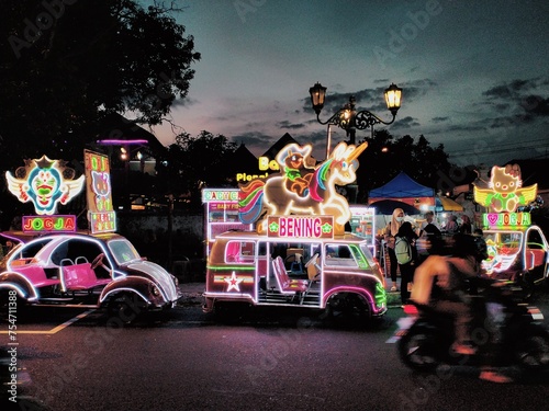Bustling night view of Alun Alun Selatan Jogja with street food vendor and unique vehicles. Landmark place in Yogyakarta, Indonesia