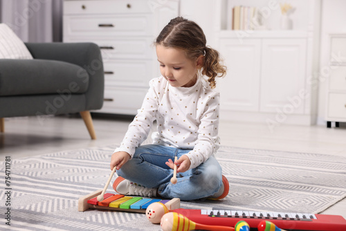 Φωτογραφία Little girl playing toy xylophone at home