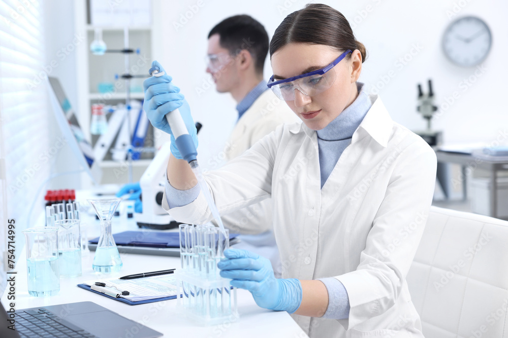 Scientist dripping sample into test tube in laboratory Scientist dripping sample into test tube in laboratory