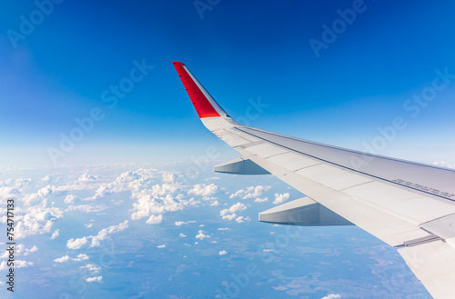 View from the airplane window at a beautiful cloudy sky and the airplane wing