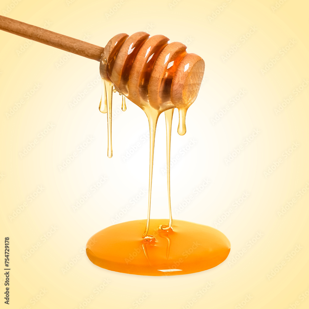 Natural honey dripping from dipper on pale yellow background Natural honey dripping from dipper on pale yellow background
