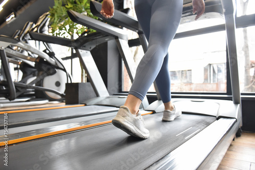 Woman running in a gym on a treadmill concept of exercise, fitness and healthy lifestyle