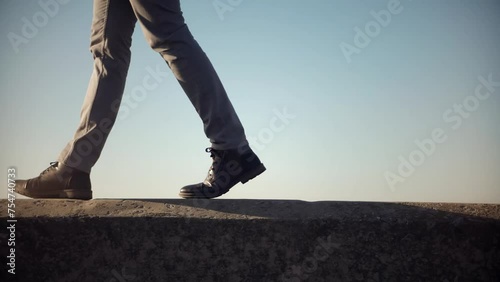 Man legs in shoes walking on parapet photo