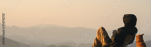 nature traveling with solo man play with dog and see sunrise with layer of mountain photo