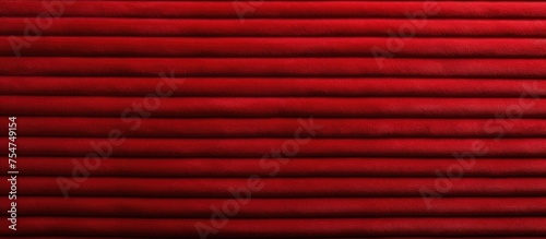 A detailed view of a vibrant red corduroy curtain hanging in a room, showcasing the texture and rich color of the fabric.