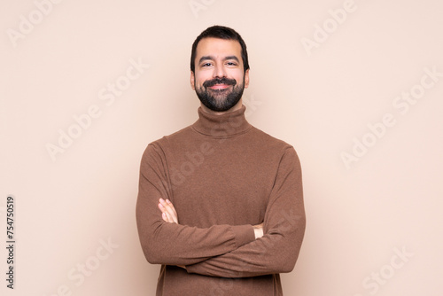 Man over isolated background keeping the arms crossed in frontal position