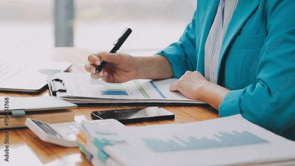 Businesswoman using phone, taking notes at office desk Businesswoman using phone, taking notes at office desk