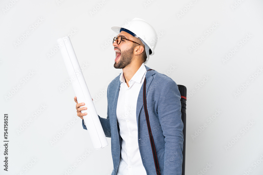 Young architect man with helmet and holding blueprints isolated on white background laughing in lateral position Young architect man with helmet and holding blueprints isolated on white background laughing in lateral position