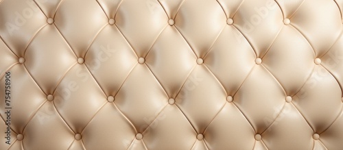 A detailed view showcasing the luxurious texture of a beige leather upholstered wall  with intricate stitching and a smooth surface. The wall exudes sophistication and elegance.