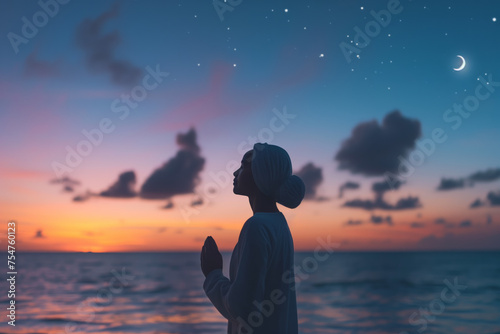 Silhouette of meditating woman during sunset  close to the sea
