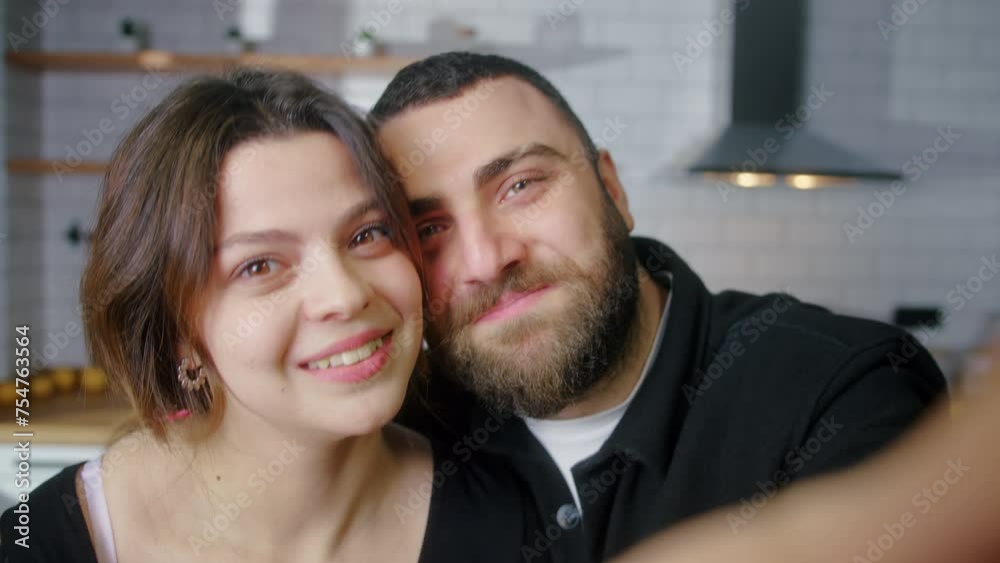 Young couple in love making a selfie using phone having fun in the kitchen looking at camera smiling Young couple in love making a selfie using phone having fun in the kitchen looking at camera smiling