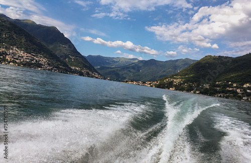 Picturesque scenic landscape nature coastal view at Lake Como in Italy with beautiful mountain hill scenery and historic old small towns and villages, mansions villas and sailing yachts