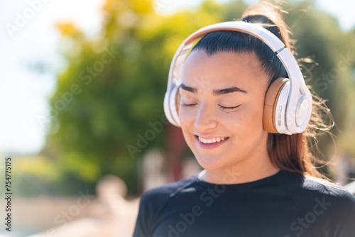 Young pretty brunette woman listening music