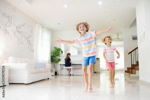 Kids play at home. Children jump, run and dance
