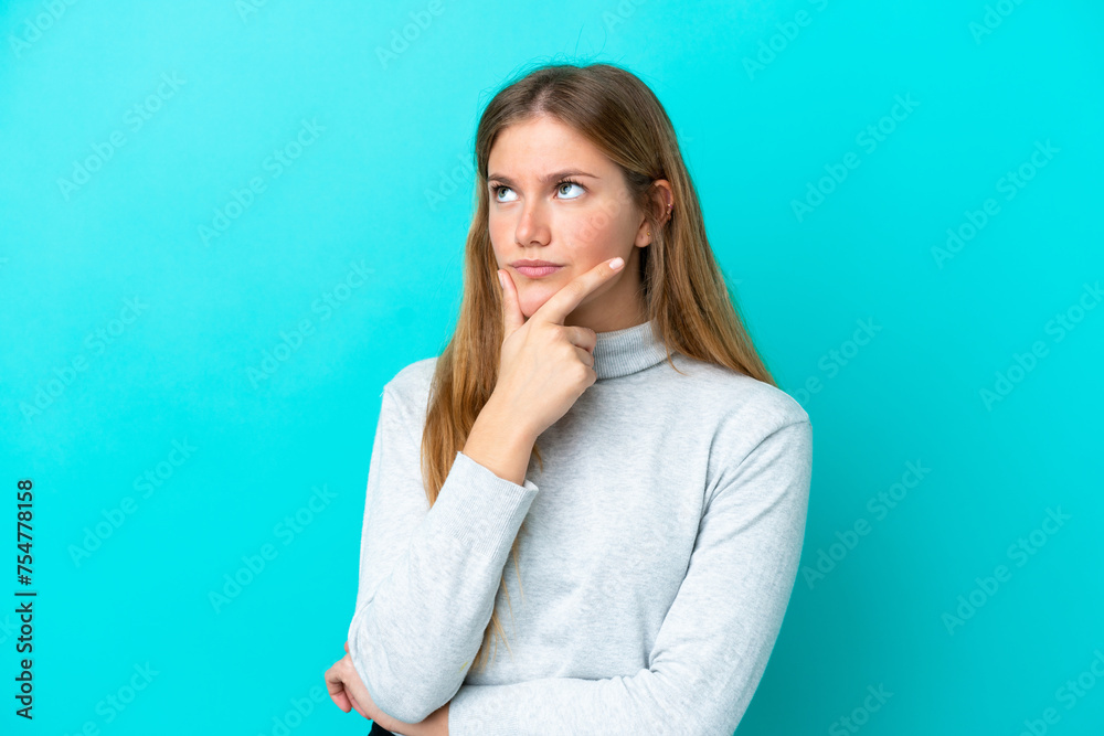 Young blonde woman isolated on blue background having doubts Young blonde woman isolated on blue background having doubts