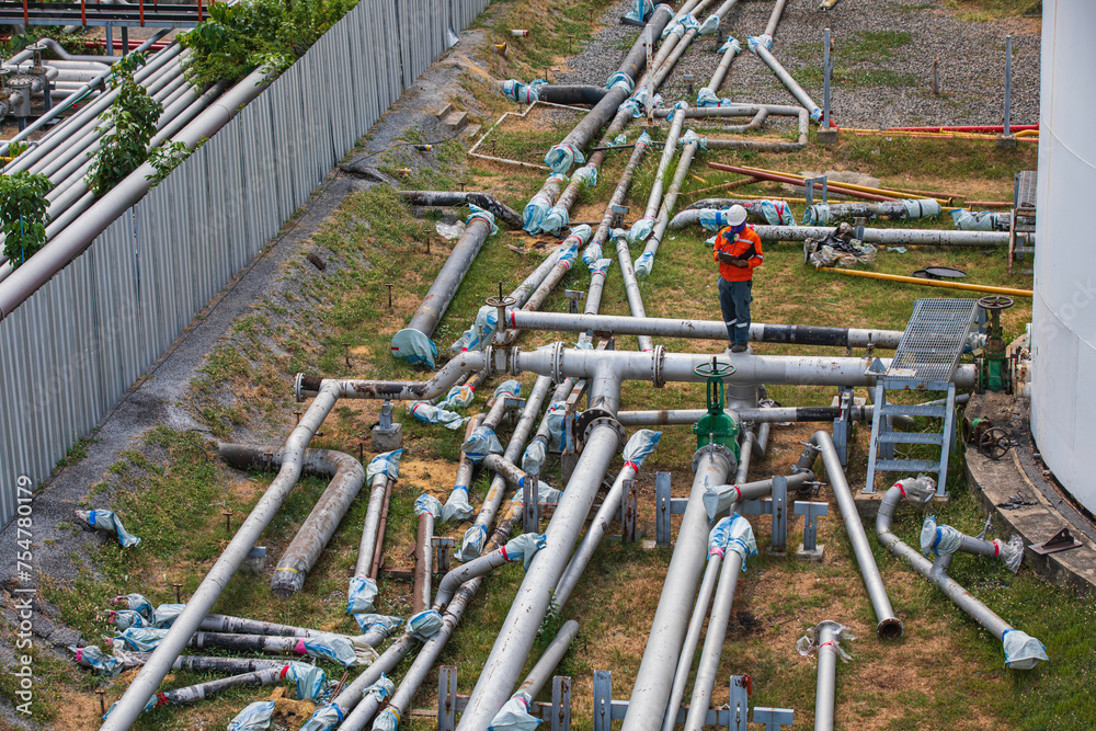 Male worker inspection at steel long pipes and pipe elbow cutting in new construction station oil factory during refinery valve of visual check record pipeline Male worker inspection at steel long pipes and pipe elbow cutting in new construction station oil factory during refinery valve of visual check record pipeline