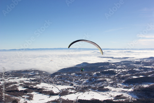 Paragliding. Paragliding in Auvergne. paragliding flight in the mountains in France. Paragliding over the clouds. Sea of clouds and paraglider. Panorama of the mountains. Puy de Dôme. Parapente.