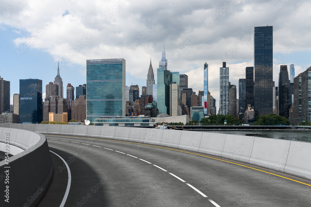 Empty urban asphalt road exterior with city buildings background. New modern highway concrete construction. Concept of way to success. Transportation logistic industry fast delivery. New York. USA. Empty urban asphalt road exterior with city buildings background. New modern highway concrete construction. Concept of way to success. Transportation logistic industry fast delivery. New York. USA.