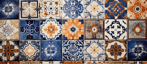 A close-up view of a tiled wall featuring a variety of vintage ceramic tiles in different colors and patterns. The tiles create a vibrant and dynamic visual display, showcasing the intricate © TheWaterMeloonProjec