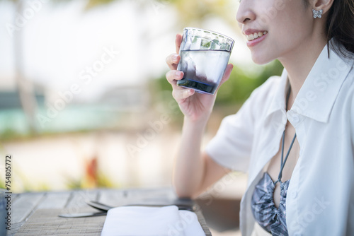 Woman drinking water, relaxation. beach resort hotel.