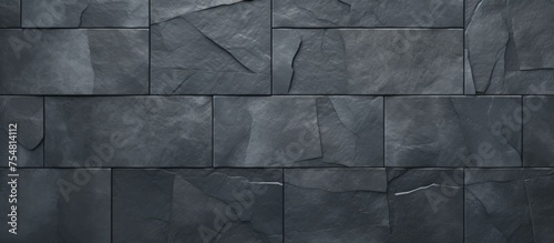 A black stone wall stands boldly against a dark background, showcasing its textured surface and sturdy construction. The stark contrast creates a dramatic visual impact.