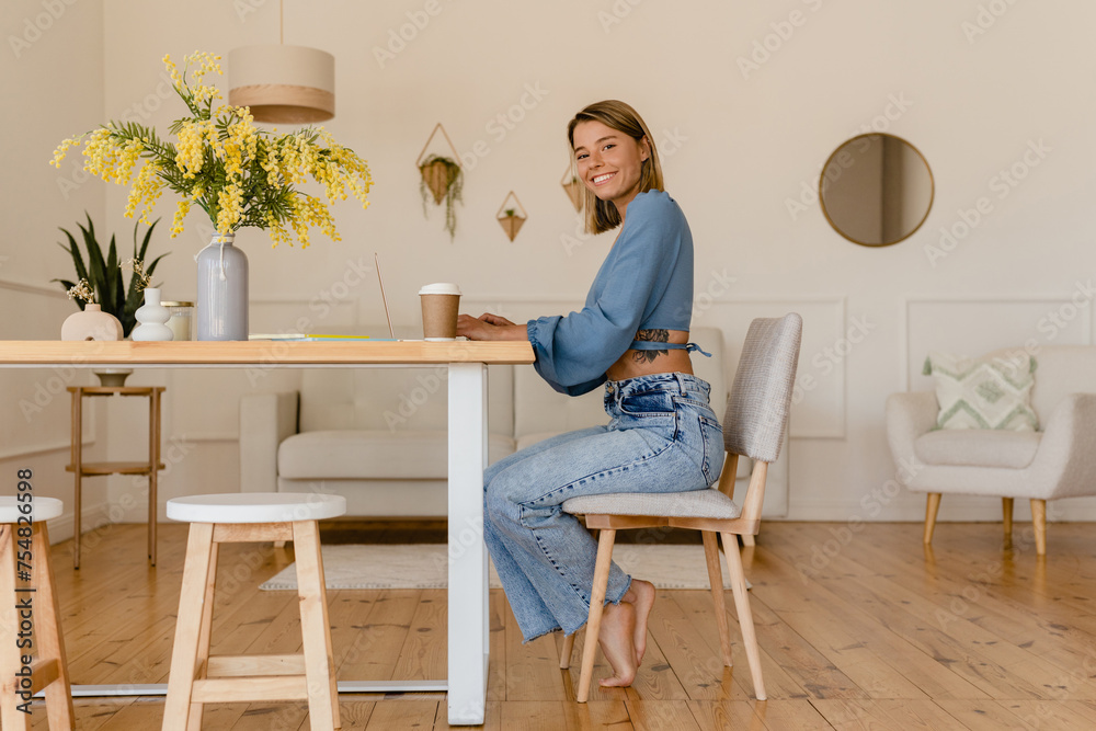 young pretty stylish woman working remote at home at table workplace, student education