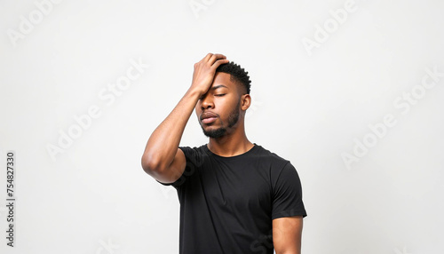 Young Adult Afro-American Male Wearing Black T-Shirt Covering His Face by Hand, Gesturing He Has Made a Big Mistake