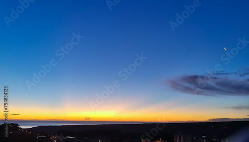 Il giorno e la notte si incontrano all’alba nel cielo sopra il mare 
