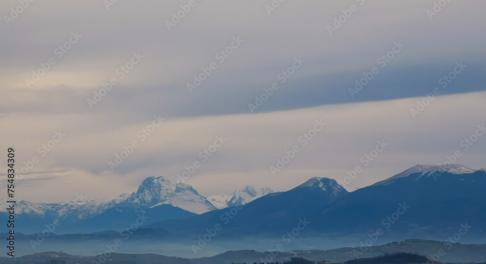 Montagne innevate avvolte da nuvole bianche