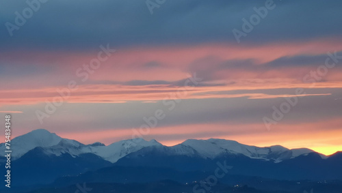 Tramonto arancio sopra le cime dei monti innevate © GjGj