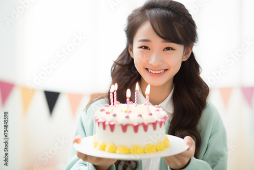 Teen pretty Japanese girl holding birthday cake
