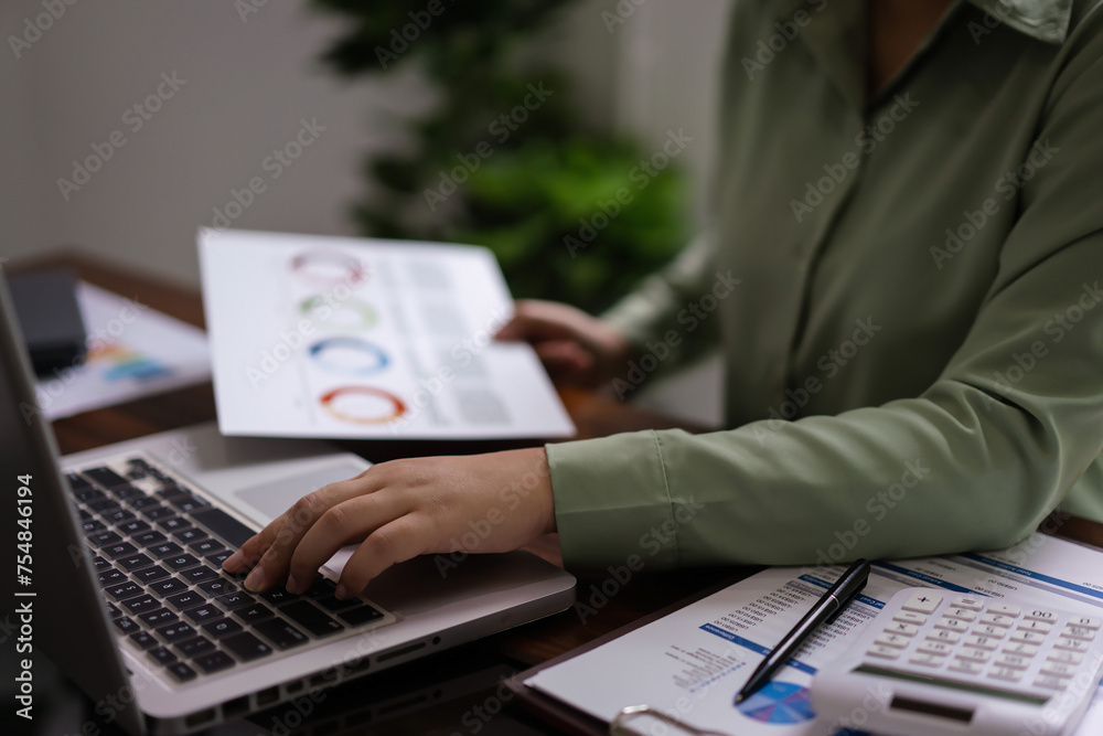 Female accountant reading document to analysis about accounting finance of business to typing data Female accountant reading document to analysis about accounting finance of business to typing data