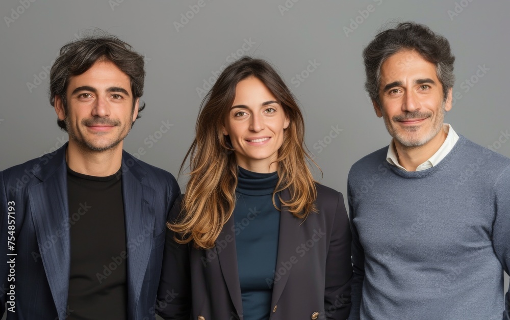 Two men and a woman of different ethnicities standing side by side, looking at the camera Two men and a woman of different ethnicities standing side by side, looking at the camera