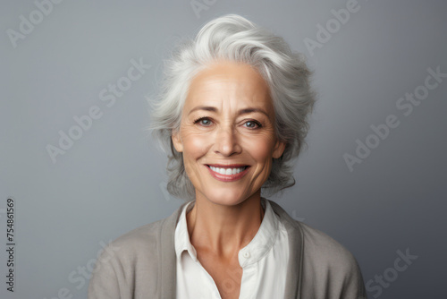Happy Mature Woman with White Hair and a Cheerful Smile in a Modern Studio Portrait