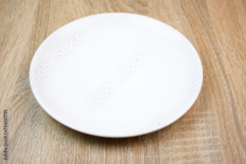 White saucer on the table. Empty plate.