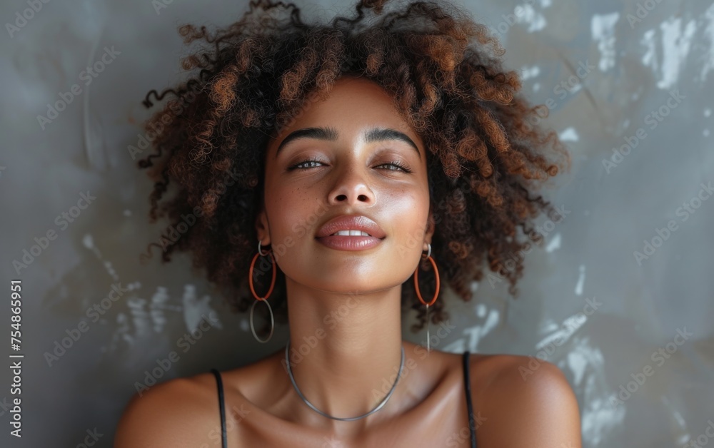 A multiracial woman with curly hair is wearing large hoop earrings A multiracial woman with curly hair is wearing large hoop earrings