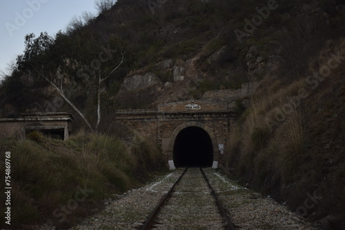railway going to the tunnel, Old train tunnel with railway in a mountain, Industrial port city