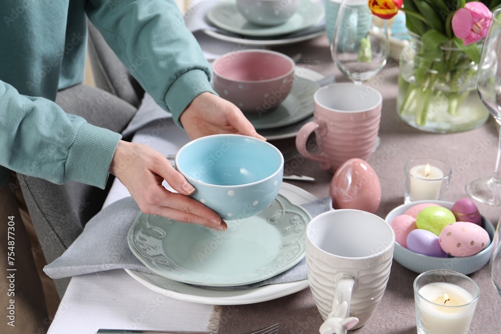 Woman setting table for festive Easter dinner at home, closeup Woman setting table for festive Easter dinner at home, closeup