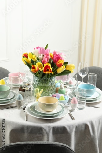 Easter celebration. Festive table setting with beautiful flowers and painted eggs