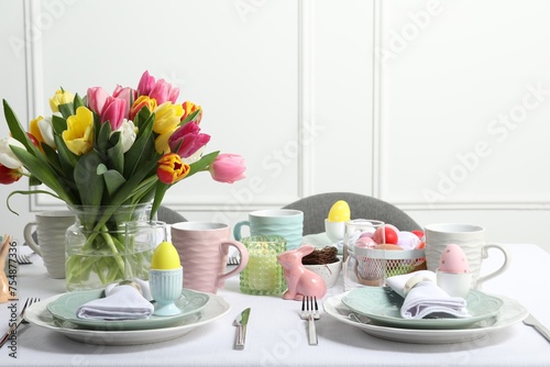 Easter celebration. Festive table setting with beautiful flowers and painted eggs