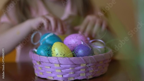 Slow-motion close-up of a child’s hands gently touching colorful Easter eggs in a wicker basket. Perfect for holiday promotions, festive marketing, and Easter-themed projects.