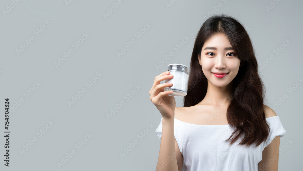 Portrait of a beautiful Asian woman holding cosmetic product. Copy space for text, advertising. Concept of beauty, anti aging, cosmetic product, skin, care, make-up, cosmetics, plastic surgery Portrait of a beautiful Asian woman holding cosmetic product. Copy space for text, advertising. Concept of beauty, anti aging, cosmetic product, skin, care, make-up, cosmetics, plastic surgery