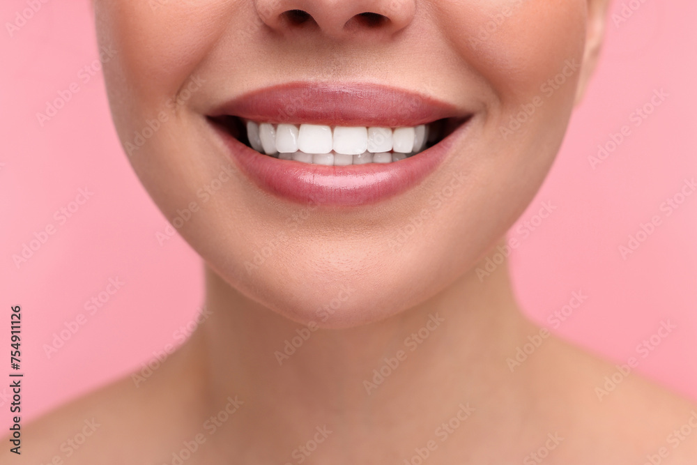 Woman with beautiful lips smiling on pink background, closeup Woman with beautiful lips smiling on pink background, closeup