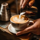 Barista crafting a beautiful latte art, showcasing coffee expertise.
