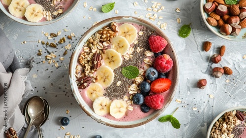 Smoothie bowl with mixed berries, banana slices, and assorted nuts and seeds on a light grey background. Healthy lifestyle and balanced diet concept.