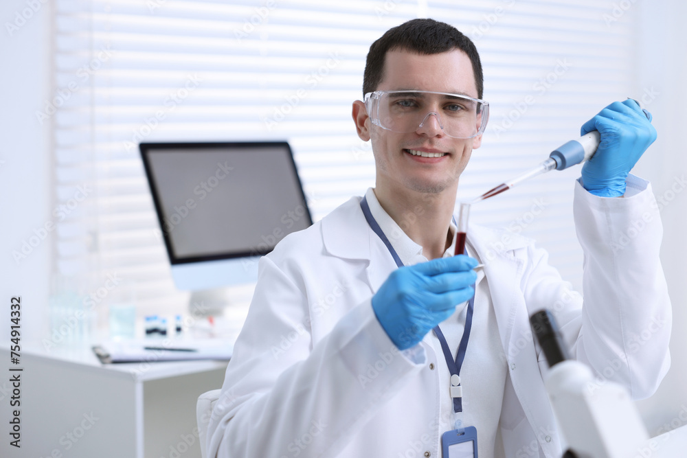 Scientist dripping sample into test tube in laboratory Scientist dripping sample into test tube in laboratory